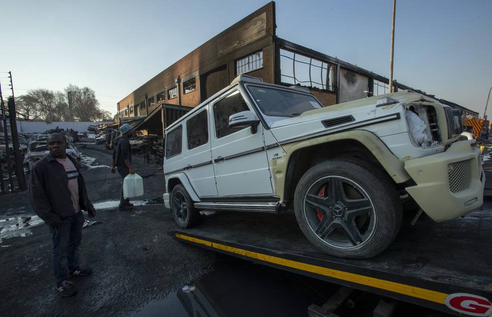En skadd bil blir kjørt bort etter kraftige demonstrasjoner i Johannesburg mot fengslingen av tidligere president Jacob Zuma. Demonstrantene antente rundt 50 biler.
Foto: AP / NTB
