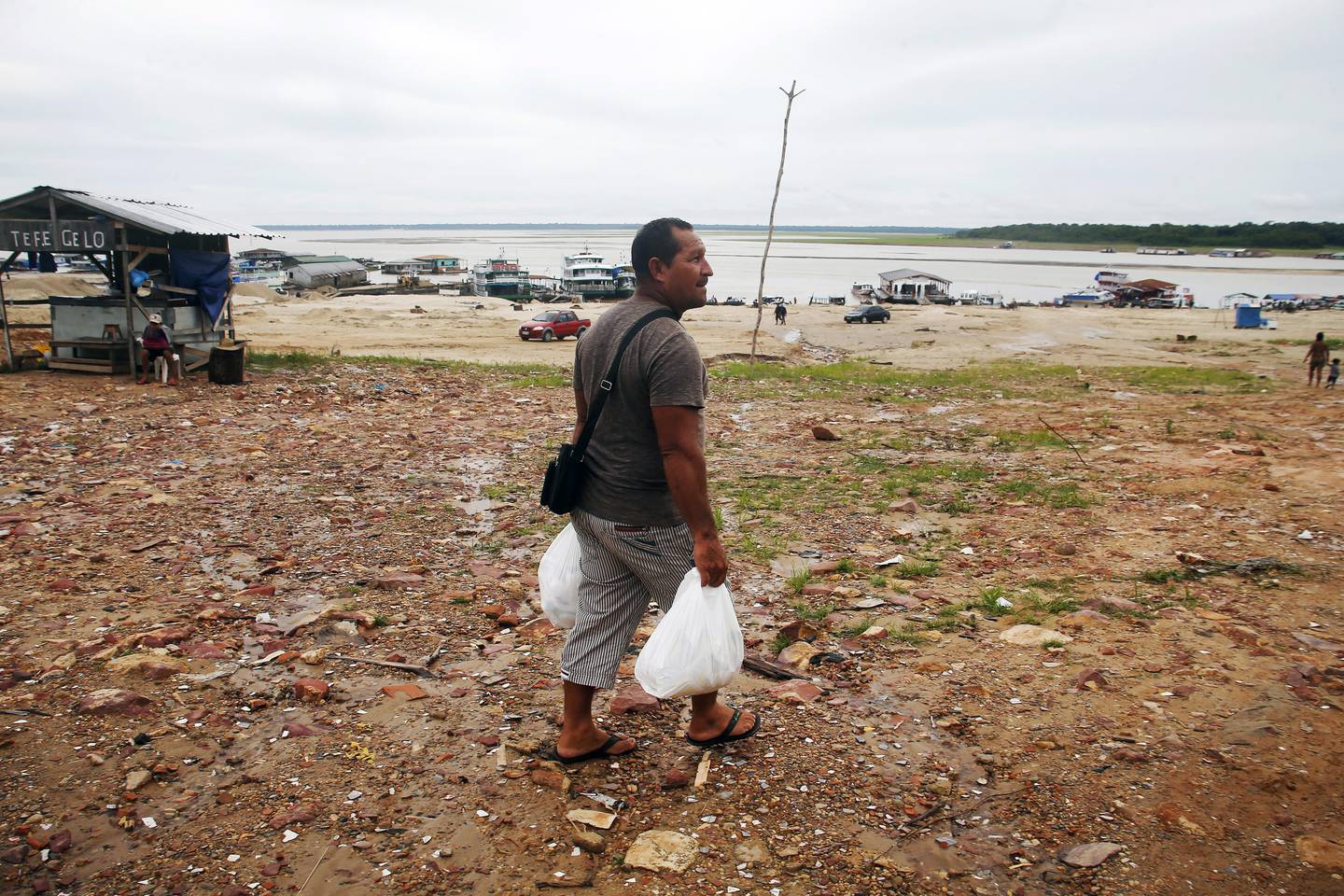 PÅVIRKET: Fiskeren Pedro Canizio da Silva går med mat i et område påvirket av tørken nær Solimões-elven, i byen Tefe. Byen ligger i delstaten Amazonas i Brasil. Hvis vannstanden i elven ikke stiger snart, vil samfunnet miste en betydelig inntektskilde.