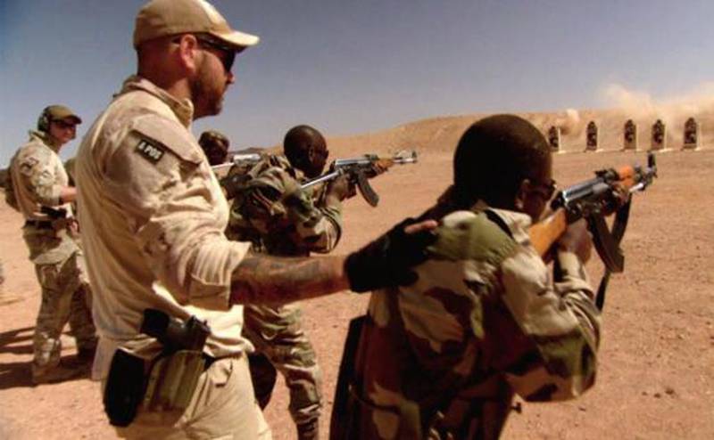 Ein norsk spesialsoldat (til venstre med norsk flagg på armen) og ein canadisk spesialsoldat driv skytetrening med soldatar frå Niger under Flintlock 2014.