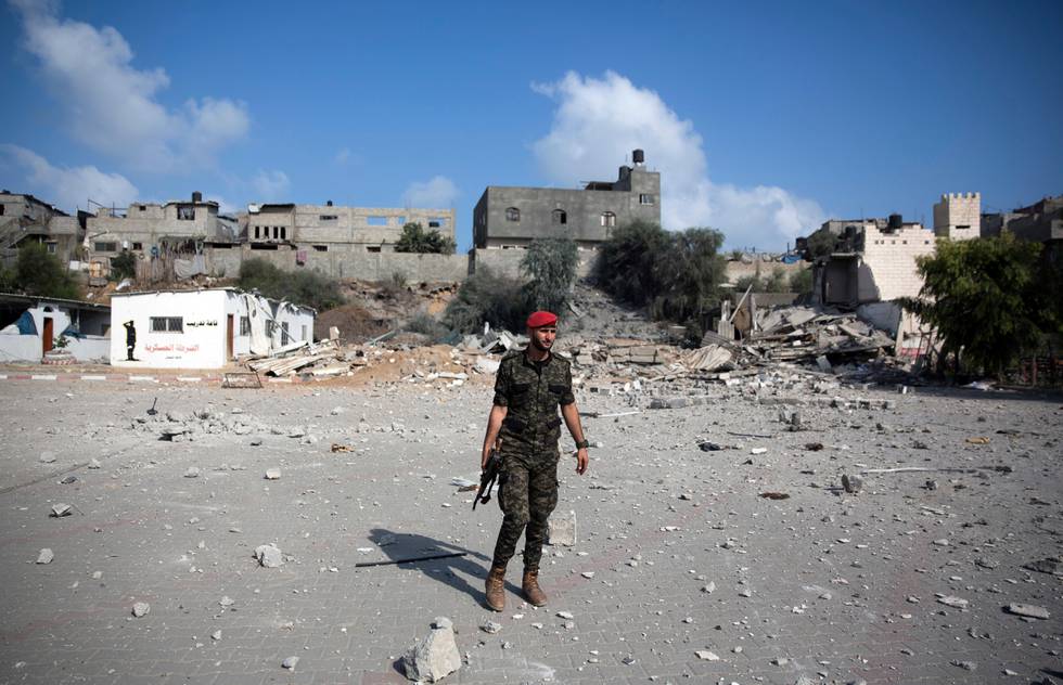 A Palestinian Hamas military policeman walks over the rubble of a site hit by Israeli airstrikes in Gaza City, Thursday, Aug. 9, 2018. Israel struck targets in the Gaza Strip after dozens of rockets were launched Wednesday from the coastal territory ruled by the Islamic militant Hamas group, the Israeli military said. (AP Photo/Khalil Hamra)