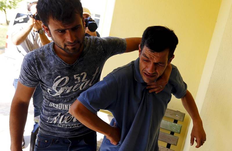 Abdullah Kurdi, far til 3 år gamle Aylan Kurdi som ble funnet død på en turiststrand torsdag, blir trøstet idet han forlater likhuset.