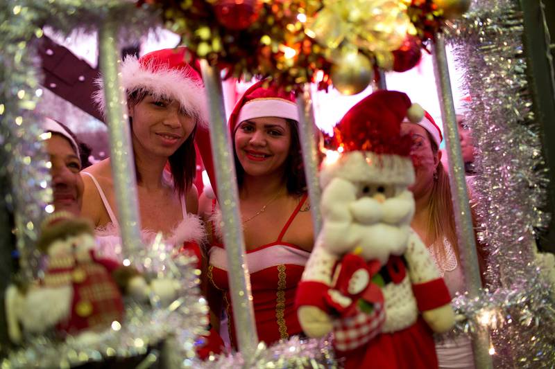 Inmates pose for a photo, looking through decorated prison bars, in the 8th annual Christmas event that includes a cell decorating contest at the Nelson Hungria Prison, in Rio de Janeiro, Brazil, Tuesday, Dec. 12, 2017. Inmates who are serving time for offenses from burglary to homicide, spent weeks decking out the cell blocks with the holiday decorations they created. The inmates used materials they had access to behind bars such as plastic bottles, paper, ground-up Styrofoam and aluminum trays. (AP Photo/Silvia Izquierdo)