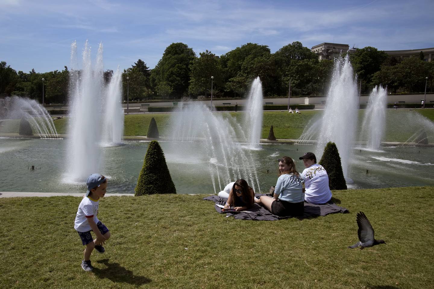 People cool down near the fountains of the Trocadero gardens in Paris, France, Wednesday, May 18, 2022. The hot weather is expected to last for several days across the country. (AP Photo/Christophe Ena)