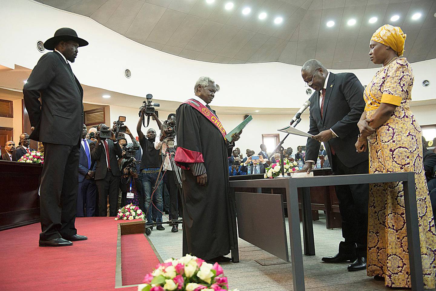 The president of South Sudan, Salva Kiir Mayardit, left, swears in Dr. Riek Machar as the first Vice President of South Sudan, in Juba, South Sudan Saturday, Feb. 22, 2020. South Sudan opened a new chapter in its fragile emergence from civil war Saturday as rival leaders formed a coalition government. (AP Photo/Charles Atiki Lomodong )