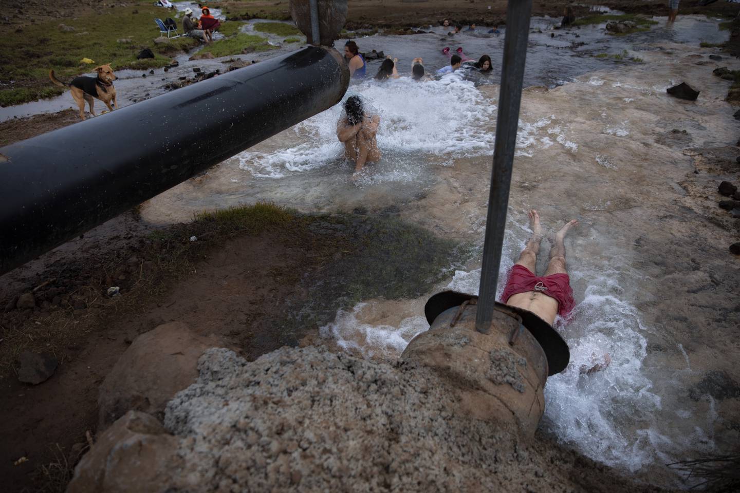 Israelis bathe in hot water coming out from a pipe at a reservoir near Mount Bental in the Israeli-controlled Golan Heights, Saturday, Dec. 4, 2021. (AP Photo/Oded Balilty)
