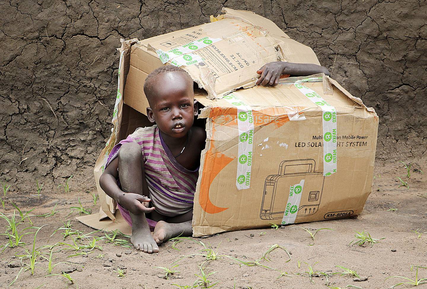 FILE - In this Friday, Aug. 17, 2018 file photo, two young boys play inside a cardboard box during an aid distribution by international humanitarian group Oxfam on the island of Nyajam, off the mainland from the opposition-held town of Nyal in Unity state, in South Sudan. An adviser to South Sudan's president said Thursday, Dec. 19, 2019 that the country is recalling its ambassador to the United States, in response to sanctions placed by the U.S. Treasury earlier this week on two senior South Sudanese officials. (AP Photo/Sam Mednick, File)