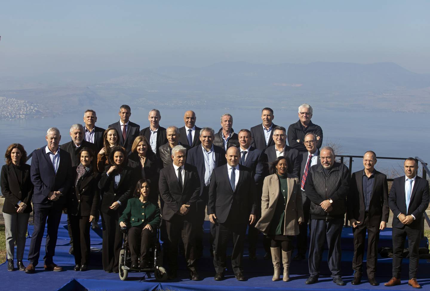 Israeli Prime Minister Naftali Bennett, fifth right front row, poses for a photo with members of the government before a weekly cabinet meeting in Kibbutz Mevo Hama, in the Israeli-occupied Golan Heights, Sunday, Dec. 26, 2021. Bennett said Sunday the country intends to double the amount of settlers living in the Israeli-controlled Golan Heights with a multimillion-dollar plan meant to further consolidate Israel’s hold on the territory it captured from Syria more than five decades ago. (Nir Elias/Pool via AP)