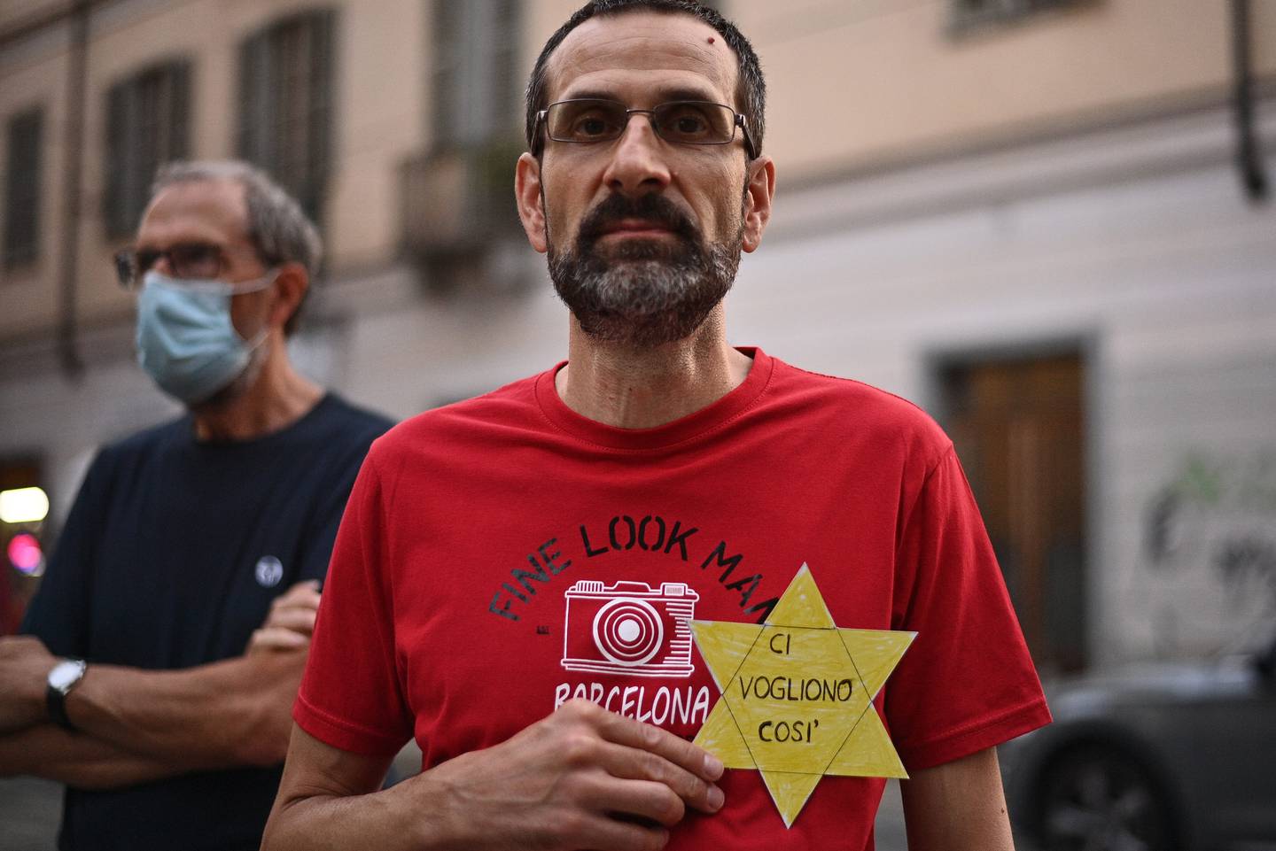 FILE - In this Wednesday, July 28, 2021 file photo, a man shows a sign shaped like a Star of David reading in Italian "They want us like this" during a protest against the COVID-19 vaccination pass in Turin, Italy. Shouts of “liberty” have echoed through Italian and French streets and squares as thousands show their opposition to plans to require vaccination cards to continue normal social activities, like dining indoors at restaurants, visiting museums or cheering home teams in stadiums. (Marco Alpozzi/LaPresse via AP, File)