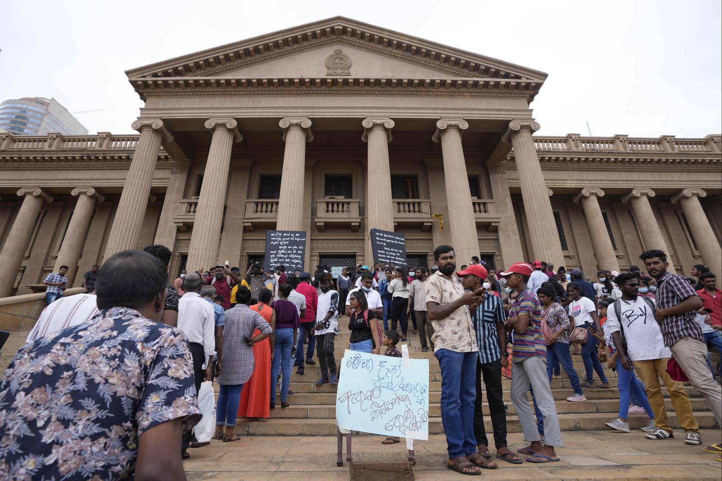 Folk står i kø for å besøke presidentpalasset i Colombo, dagen etter at palasset ble stormet og president Gotabaya Rajapaksa måtte love å trekke seg. Foto: Eranga Jayawardena / AP / NTB