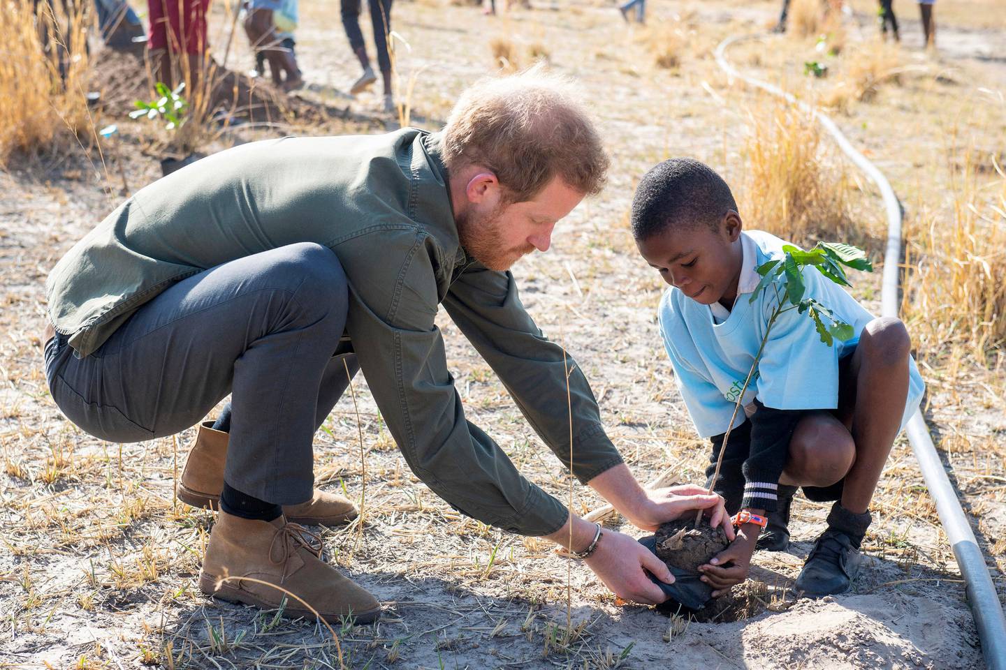 Britain's Prince Harry attends a tree planting event with local school children, at the Chobe Tree Reserve, in Botswana, Thursday Sept. 26, 2019, on day four of the royal tour of Africa. The 10-day, multi-country tour includes stops for Harry in Botswana, Angola and Malawi with a focus on wildlife protection, mental health and mine clearance — a topic given global attention by Harry's late mother, Princess Diana, when she walked through an active mine field during an Africa visit years ago. (Dominic Lipinski/Pool via AP)