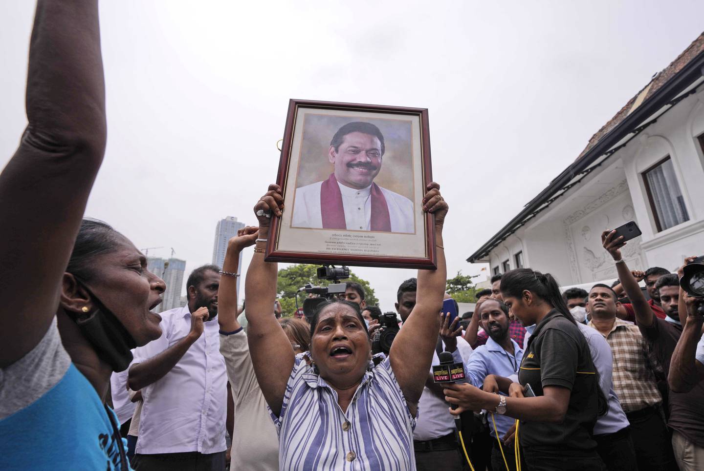 Tilhengere av Sri Lankas regjering protesterte mandag mot statsminister Mahinda Rajapaksas avgang. Foto: AP / NTB