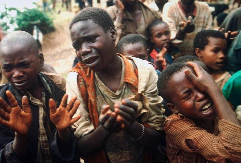 Rewandan refugee children plead with Zairian soldiers, Saturday, August 20, 1994, to be let across the bridge separating Rwanda and Zaire where their mother had crossed moments before the Zairean soldiers closed the border. There are some 10,000 refugees stuck on the Rwandan side, some are leaving their belongings behind and swimming across or buying places on Zairian boats. (AP Photo/Jean-Marc Bouju)