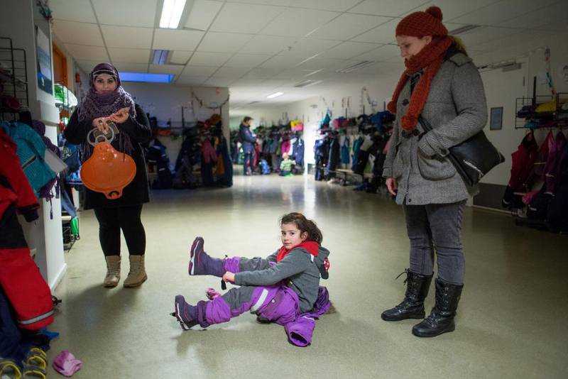Laial Ayoub og datteren Janet gjør seg klare for å gå ut i vintersnøen og ta helg på fredag ettermiddag ved Ellingsrudåsen barneskole i Oslo. Skolen har en elevmasse på rundt 40 prosent etnisk norske, og 60 prosent fra andre vestlige eller ikke-vestlige land. Alle deltar i barnebursdag.