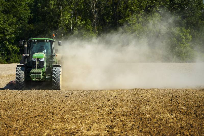 Støvskyen står etter traktoren som er ute på markene i Til-Chatel i Frankrike.