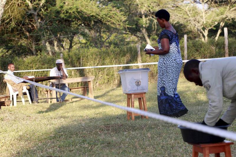 En kvinne leverer inn sin stemmeseddel i Uganda torsdag. 