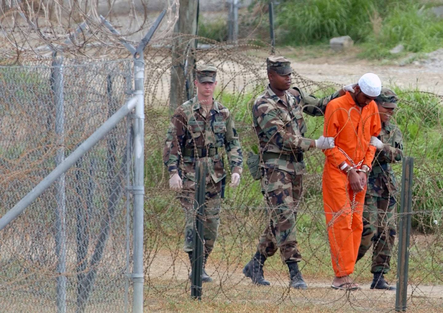 FILE - In this Feb. 6, 2002, file photo a detainee is led by military police to be interrogated by military officials at Camp X-Ray at the U.S. Naval Base at Guantanamo Bay, Cuba. At the time the image was taken there were 158 al-Qaida and Taliban prisoners being held at Camp X-Ray. The White House says it intends to shutter the prison on the U.S. base in Cuba, which opened in January 2002 and where most of the 39 men still held have never been charged with a crime. (AP Photo/Lynne Sladky, File)