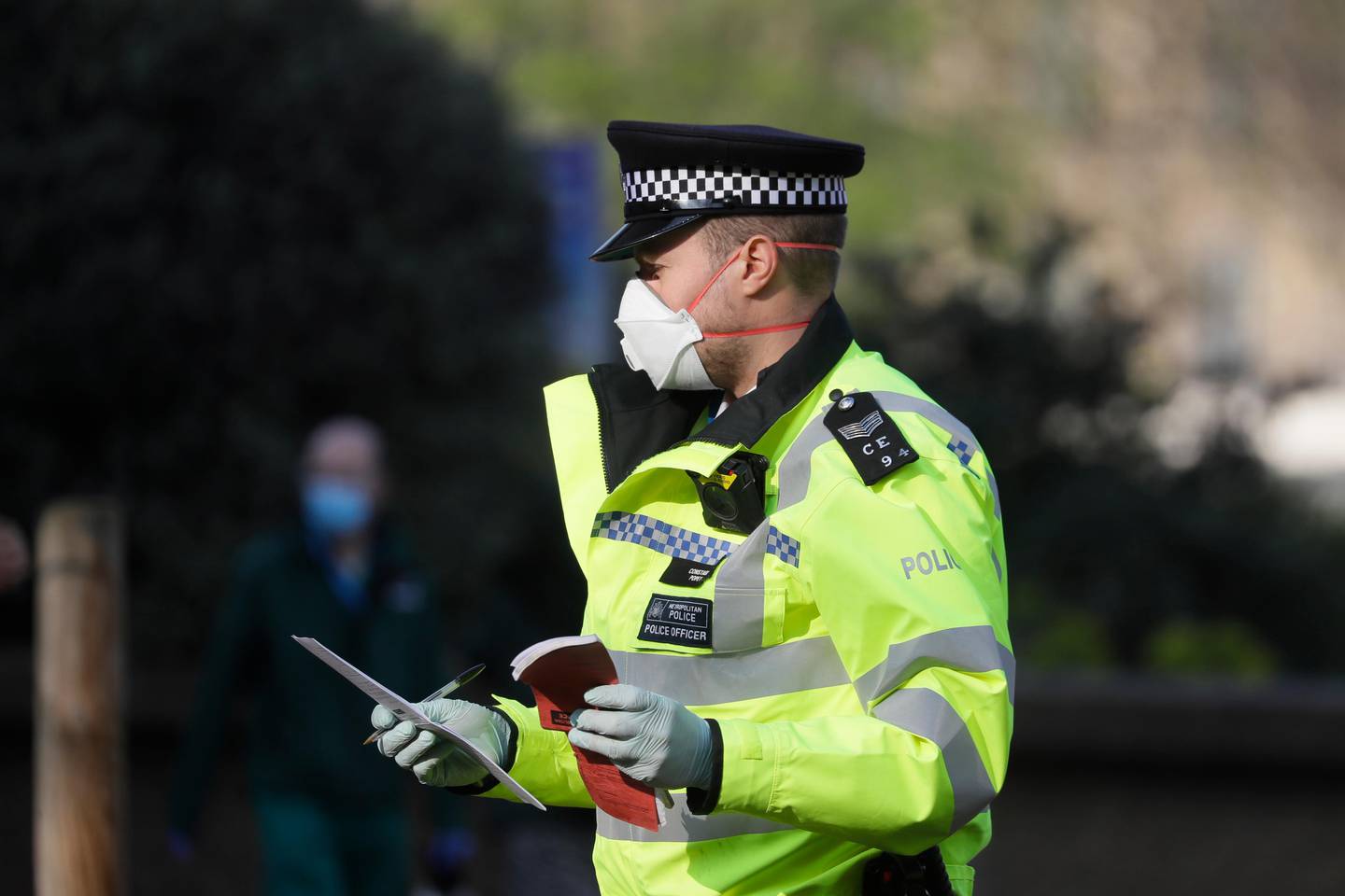 A British police officer wears a 3M face mask, with few police officers in Britain seen wearing face masks since the outbreak of the coronavirus, outside St Thomas' Hospital, in London, where Prime Minister Boris Johnson remains in intensive care as his coronavirus symptoms persist, Thursday, April 9, 2020. British Prime Minister Boris Johnson remains in intensive care with the coronavirus but is improving and sitting up in bed, a senior government minister said Wednesday, as the U.K. recorded its biggest spike in COVID-19 deaths to date. The new coronavirus causes mild or moderate symptoms for most people, but for some, especially older adults and people with existing health problems, it can cause more severe illness or death. (AP Photo/Kirsty Wigglesworth)