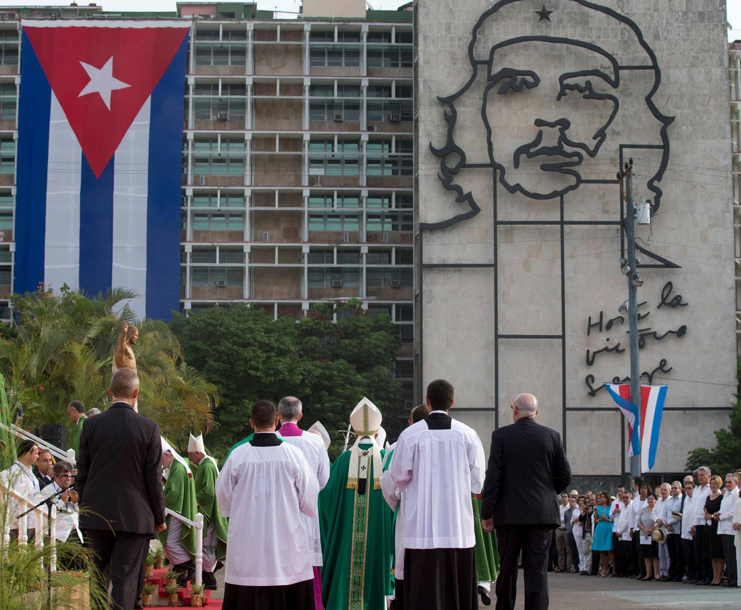 Pope Francis, center, arrives for Mass at Revolution Plaza in Havana, Cuba, Sunday, Sept. 20, 2015, where a sculpture of revolutionary hero Ernesto "Che" Guevara and a Cuban flag decorate a government building. Pope Francis opens his first full day in Cuba on Sunday with what normally would be the culminating highlight of a papal visit: Mass before hundreds of thousands of people in Havana's Revolution Plaza. (AP Photo/Alessandra Tarantino)