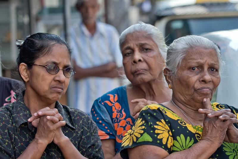 People pray during a nationwide three-minutes silence as a tribute to Easter Sunday attack victims in Colombo, Sri Lanka, Tuesday, April 23, 2019. Easter Sunday bombings of churches, luxury hotels and other sites was Sri Lanka's deadliest violence since a devastating civil war in the South Asian island nation ended a decade ago. (AP Photo/Gemunu Amarasinghe)