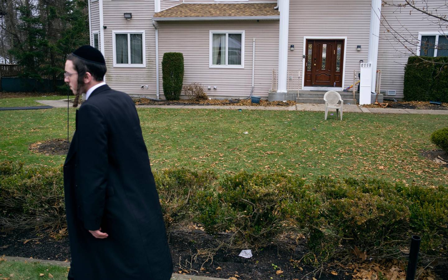 A man walks near a rabbi's residence in Monsey, N.Y., Sunday, Dec. 29, 2019. A day earlier, a knife-wielding man stormed into the home and stabbed multiple people as they celebrated Hanukkah in the Orthodox Jewish community. (AP Photo/Craig Ruttle)