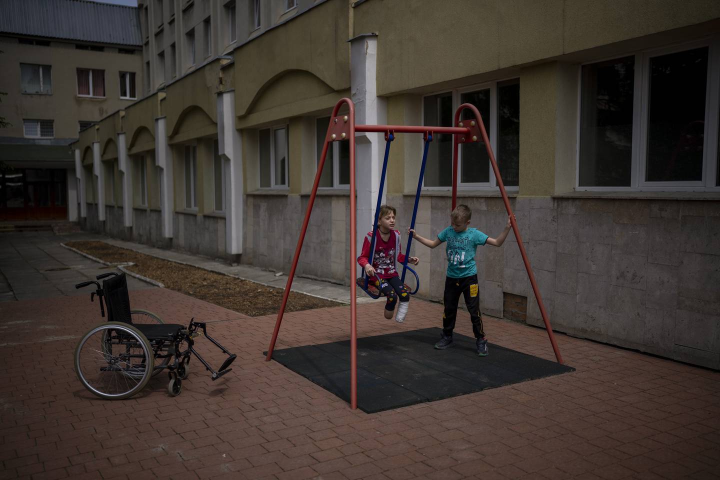 Yarik Stepanenko, 11, pushes his twin-sister Yana on a swing outside a public hospital in Lviv, Ukraine, Thursday, May 12, 2022. On April 8, a missile struck the train station in the eastern city of Kramatorsk where Yana, Yarik and their mother Natasha were planning to catch an evacuation train heading west and, they hoped, to safety. Yana lost two legs, one just above the ankle, the other higher up her shin. Natasha lost her left leg below the knee. Yarik, left at the station in the chaos of the attack, was uninjured and has been reunited with his mother and sister. (AP Photo/Emilio Morenatti)