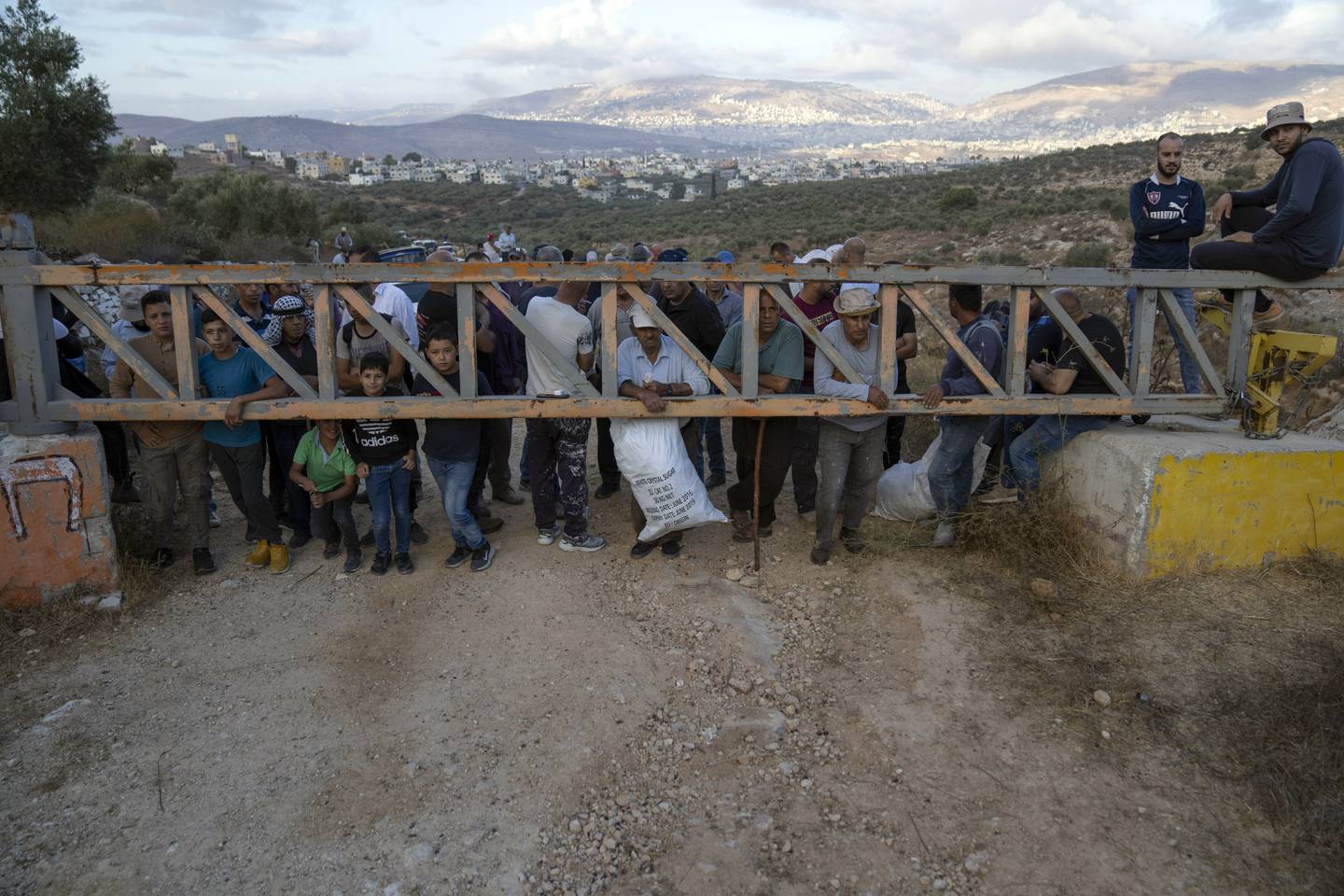 VENTER: Palestinske bønder venter på tillatelse fra israelske soldater for å slippe inn på olivenåkrene sine.