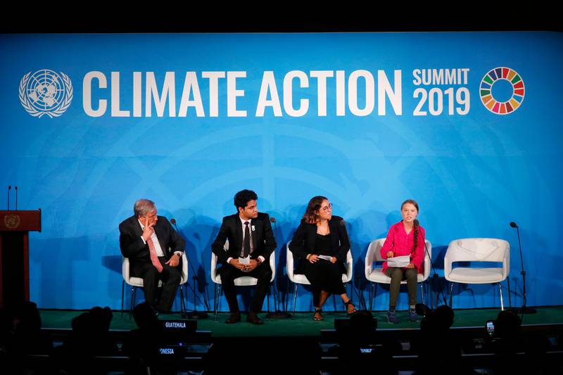 United Nations Secretary-General Antonio Guterres, far left, and young environmental activists look on as Greta Thunberg, of Sweden, far right, addresses the Climate Action Summit in the United Nations General Assembly, at U.N. headquarters, Monday, Sept. 23, 2019. (AP Photo/Jason DeCrow)