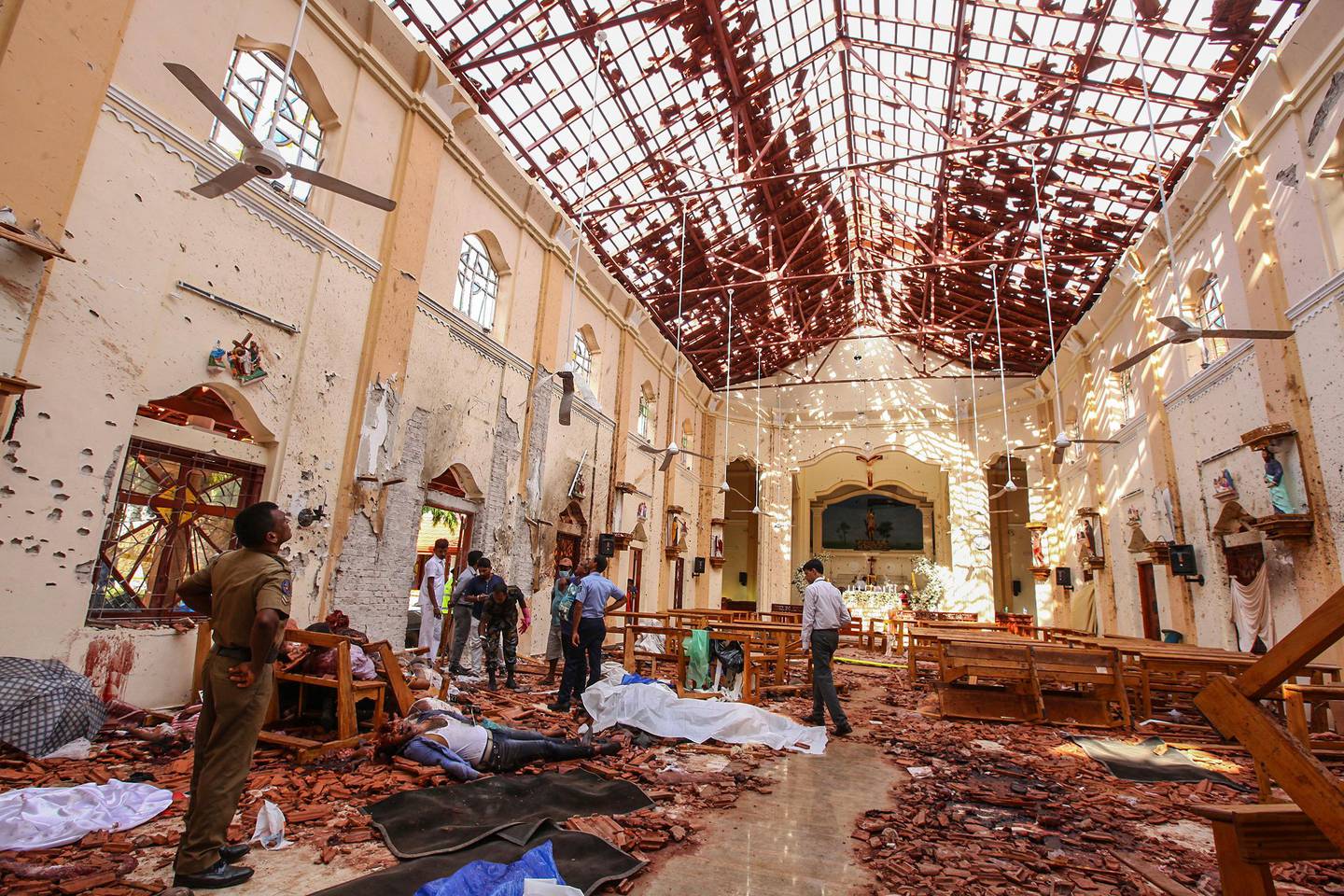 FILE - In this April 21, 2019, file photo, dead bodies of victims lie inside St. Sebastian's Church damaged in bomb blast in Negombo, north of Colombo, Sri Lanka. The Indian Ocean island nation of Sri Lanka, which will elect a new president on Saturday, Nov. 16, 2019 has had a tumultuous history. Since gaining independence from British colonial rule in 1948, the country has seen three major armed conflicts in which hundreds of thousands have died. It also has had its share of natural disasters. As it prepares to elect its seventh president, Sri Lanka remains a divided nation, with ethnic, political and economic issues unresolved. (AP Photo/Chamila Karunarathne, File)