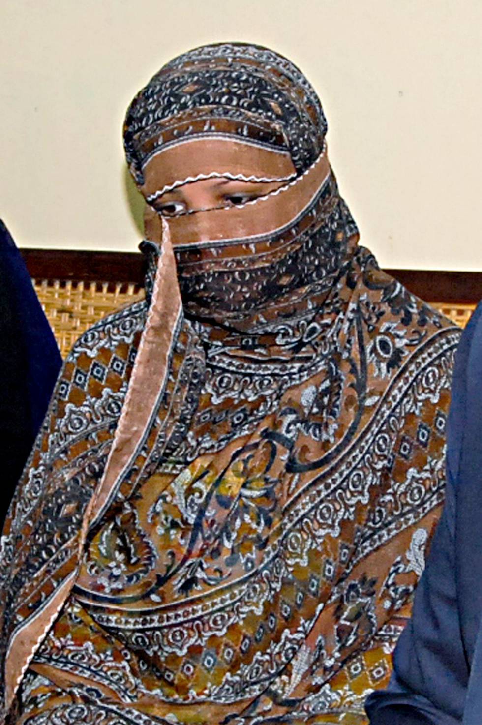 FILE - In this Nov. 20, 2010, file photo, Asia Bibi, a Pakistani Christian woman, listens to officials at a prison in Sheikhupura near Lahore, Pakistan. Pakistan's Supreme Court has postponed its ruling on the final appeal of Bibi who has been on death row since 2010 after being convicted of blasphemy against Islam. Bibi's case has generated international outrage, but within Pakistan it has fired up radical Islamists, who use the blasphemy law to rally supporters and intimidate mainstream political parties. (AP Photo, File)