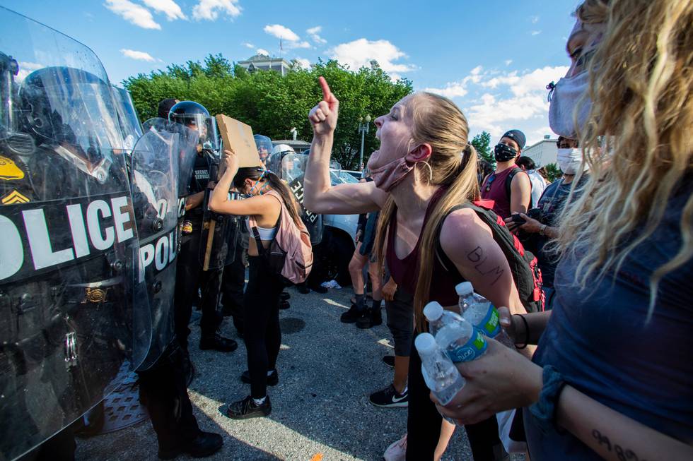 Demonstrators yell at police in riot gear as they protest the death of George Floyd, Saturday, May 30, 2020, near the White House in Washington. Floyd died after being restrained by Minneapolis police officers on Memorial Day. (AP Photo/Manuel Balce Ceneta)