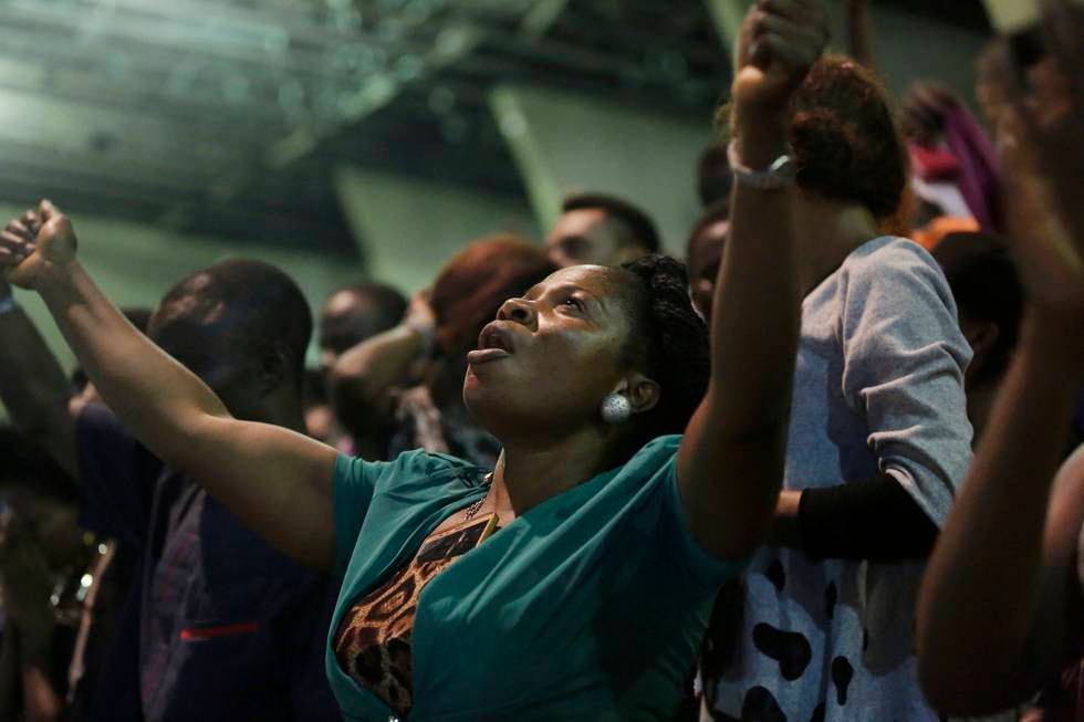 A woman expresses her faith as some thousands of Christians sing and dance during The Experience gospel concert at Tafawa Balewa square in Lagos, Nigeria, Friday, Dec. 2, 2016. This is one of Nigeria's largest gospel concerts. (AP Photo/Sunday Alamba)