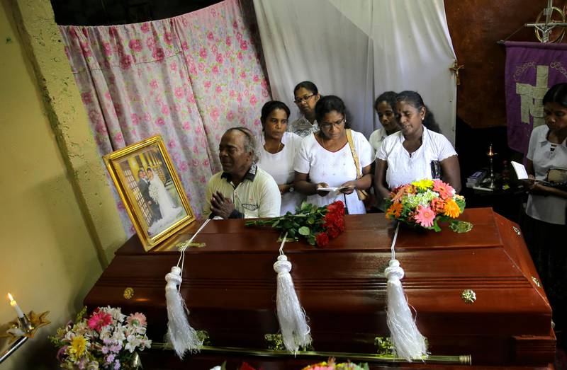 A Sri Lankan family mourns next to the coffin of their family member, a victim of Easter Sunday bombing, in Colombo, Sri Lanka, Tuesday, April 23, 2019. The six near-simultaneous attacks on three churches and three luxury hotels and three related blasts later Sunday were the South Asian island nation's deadliest violence in a decade while Sri Lanka police arrested 40 suspects in the wake of a state of emergency that took effect Tuesday giving the military war-time powers. (AP Photo/Eranga Jayawardena)