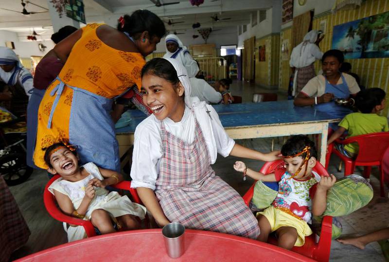 En nonne som er tilknyttet ordenen Mor Teresa startet i India, leker med barn ved et barnehjem i Calcutta. Også barnehjemmet ble grunnlagt av den verdenskjente nonnen. 