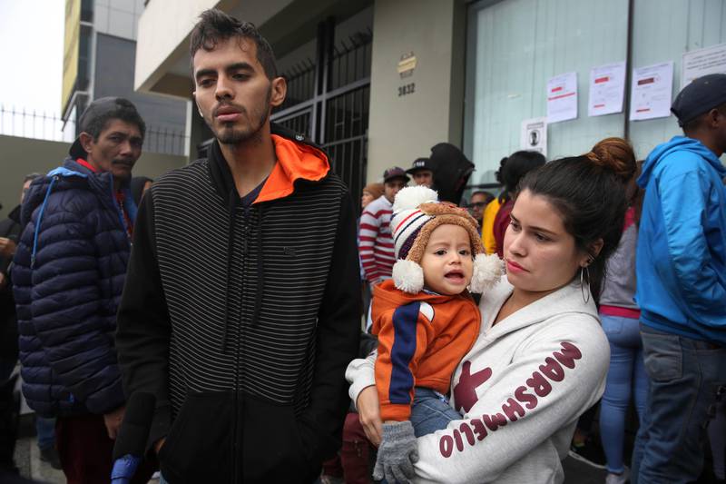 Venezuelan migrant couple Johan Alvarez and Daniela Tovar, with their son Matias, speak during an interview outside a refugee office run by Peru's Special Commission for Refugees Executive Secretariat, where they wait to apply for refugee status in Lima, Peru, Tuesday, June 18, 2019. When Alvarez, 25, was unable to provide more than one meal a day for his young family he knew it was time to leave Venezuela. In Peru he works at a candle factory and is able to provide three meals a day. (AP Photo/Martin Mejia)