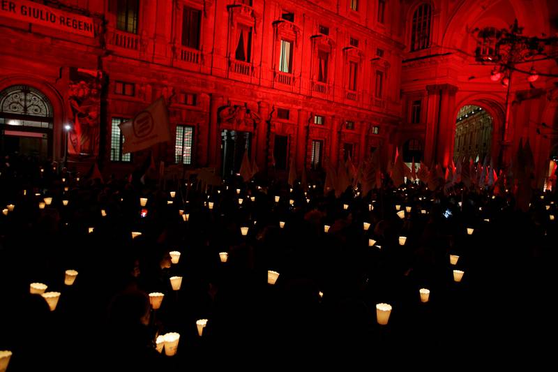 People stage a torchlight procession in front of Milan's town hall, Italy, Monday, Dec. 10, 2018, on the occasion of Human Rights Day and the 70th anniversary of the Universal Declaration of Human Rights. (AP Photo/Luca Bruno)