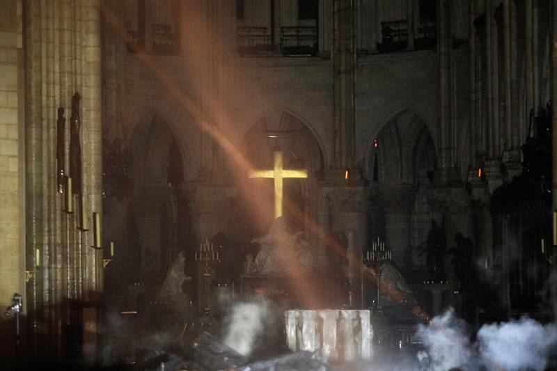 Smoke is seen around the alter inside Notre Dame cathedral in Paris, Monday, April 15, 2019. A catastrophic fire engulfed the upper reaches of Paris' soaring Notre Dame Cathedral as it was undergoing renovations Monday, threatening one of the greatest architectural treasures of the Western world as tourists and Parisians looked on aghast from the streets below. (Philippe Wojazer/Pool via AP)