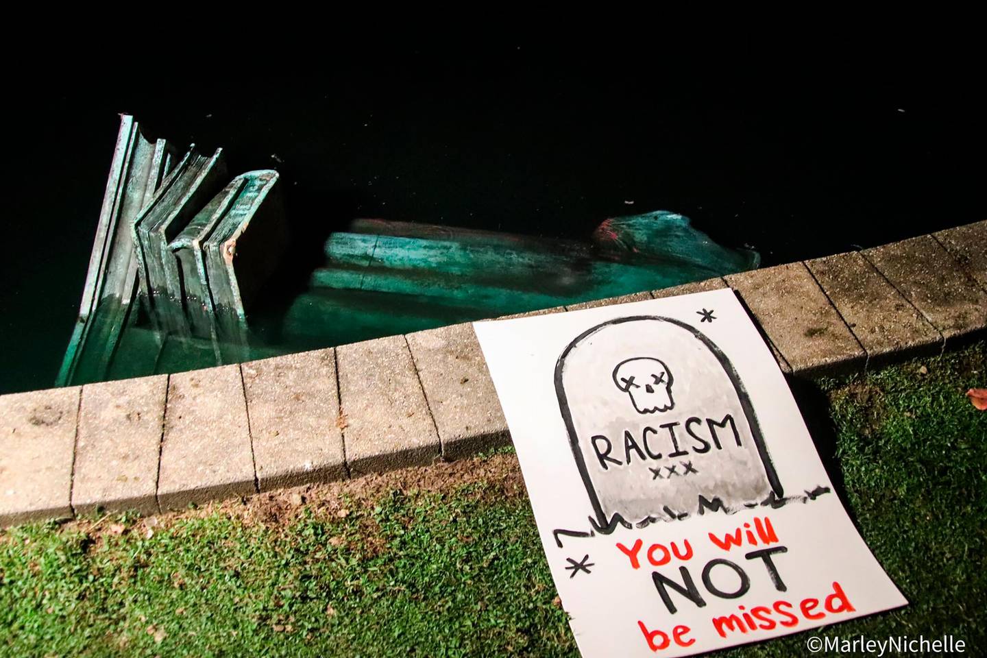 A statue of Christopher Columbus is in the water at Byrd Park in Richmond, Va. Tuesday, June 9, 2020, after it was torn down by protesters. The figure was toppled less than two hours after protesters gathered in the citys Byrd Park were chanting for the statue to be taken down, news outlets reported. (@marleynichelle via AP)