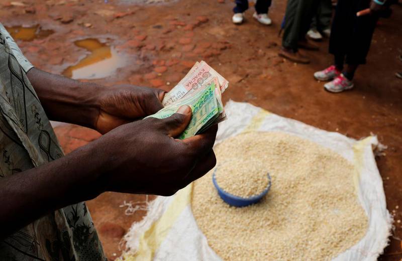 En handelsmann teller opp penger for mais han selger på et marked nær hovedstaden Lilongwe i ­Malawi. Matprisene har steget kraftig i mange afrikanske land som følge av langvarig tørke.