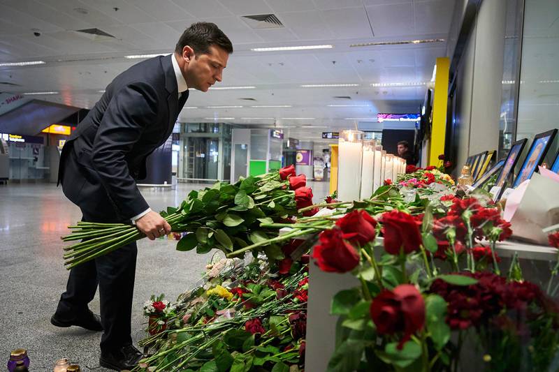 In this handout photo provided by the Ukrainian Presidential Press Office, Ukrainian President Volodymyr Zelenskiy lays flowers at a memorial of the flight crew members of the Ukrainian 737-800 plane that crashed on the outskirts of Tehran, at Borispil international airport outside in Kyiv, Ukraine, Thursday, Jan. 9, 2020. A Ukrainian passenger jet carrying 176 people has crashed just minutes after taking off from the Iranian capital's main airport, turning farmland on the outskirts of Tehran into fields of flaming debris and killing all on board. (Ukrainian Presidential Press Office via AP)