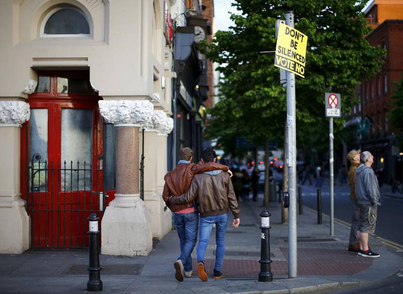 To menn går forbi en plakat i Dublin sentrum som oppfordrer til å stemme nei til at Irland skal tillate homofile ekteskap.