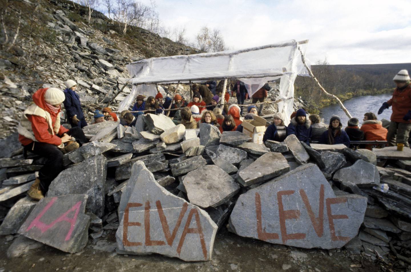Finnmarksvidda 197910
Demonstrasjon mot utbyggingen av Alta-Kautokeino-vassdraget. Flere hundre mennesker har slått leir ved nullpunktet i Stilla for å hindre anleggsarbeidet  og kraftutbyggingen. Parolen " La elva leve" er malt på steiner.
Foto: Erik Thorberg / NTB