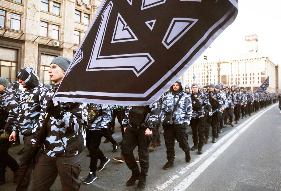 Volunteers with the right-wing paramilitary Azov National Corps take part in a march, less than a month before the country's presidential vote along the main street in Kiev, Ukraine, Saturday, March 2, 2019. (AP Photo/Efrem Lukatsky)