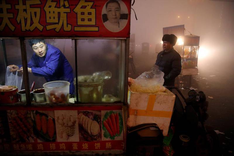 Gatekjøkkenet holdes åpent i Shengfang i Hebei-provinsen tross alarmerende helsefarlig luft. Myndighetene har ambisiøse kutt for utslippskutt.