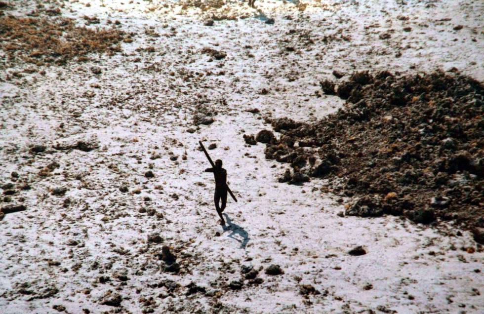 In this photo released by the Indian Coast Guard, a Sentinel tribal man aims with his bow and arrow at an Indian Coast Guard helicopter as it flies over their island for survey in Indias Andaman and Nicobar archipelago, Tuesday, Dec, 28, 2004. From circumstantial evidence, officials say fate and the ancient knowledge of secret signals in the wind and sea have combined to save the five indigenous tribes living for centuries in the southern archipelago of Andaman and Nicobar from the catastrophic tsunami that lashed Asian coastlines last week. But the fate of the tribes _ on the verge of extinction _ will be known with certainty only after officials complete a survey of their remote islands beginning Wednesday. (AP Photo/Indian Coast Guard, HO)