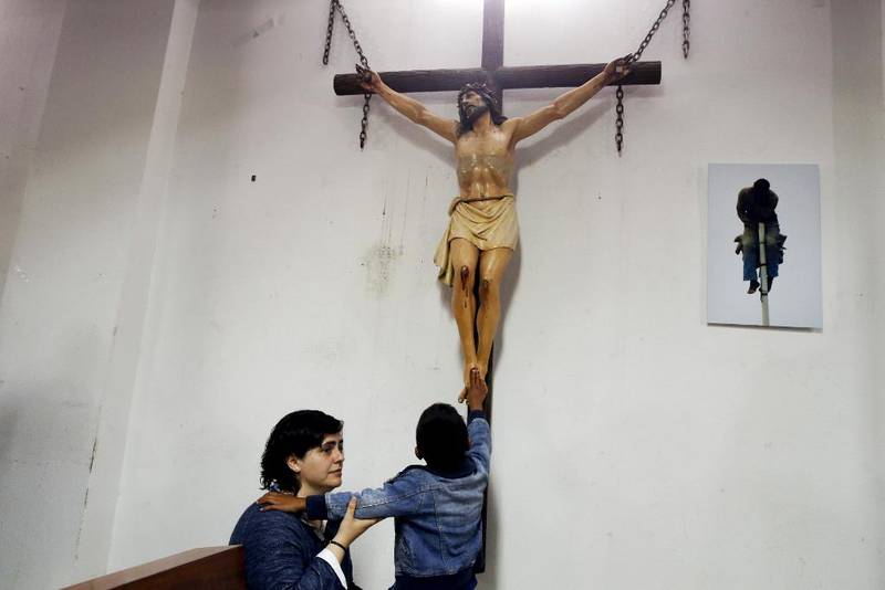 En gutt rører ved føttene på en Kristus-figur i en kirke i Madrid. Ann Heberlein kan rase mot Gud, og spør hvor han hvar den natten hun ble voldtatt.