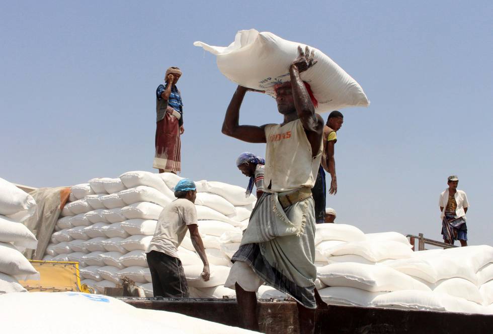 In this Sept. 21, 2018, file photo, men deliver U.N. World Food Programme (WFP) aid in Aslam, Hajjah, Yemen. The World Food Program chief warned Thursday, Sept. 17, 2020, that millions of people are closer to starvation because of the deadly combination of conflict, climate change and the COVID-19 pandemic and he urged donor nations and billionaires to help feed them and ensure their survival. (AP Photo/Hammadi Issa, File)