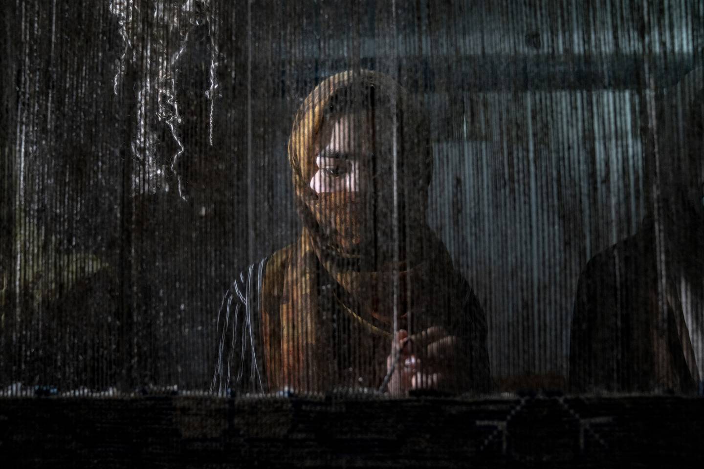 En ung afghansk kvinne vever et teppe på en tradisjonell teppefabrikk i Kabul. Foto: Ebrahim Noroozi / AP / NTB
