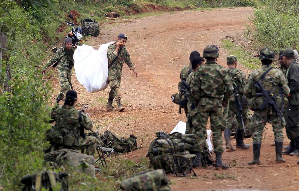 Colombia venter fortsatt på en fredsavtale etter 51 år med borgerkrig mellom myndighetene og geriljabevegelsen FARC. Her bærer regjeringssoldater bort en fallen kamerat etter et angrep fra opprørere i landsbyen La Esperanza i april. Foto: Jaime Saldarriaga/NTB scanpix