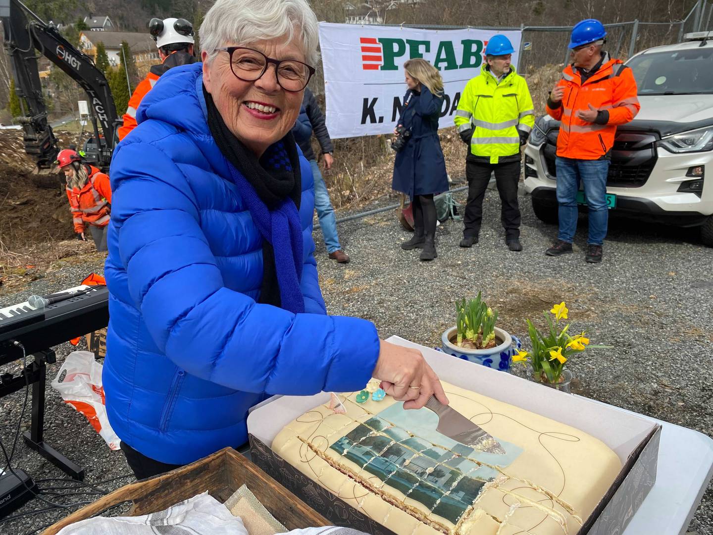 FEIRING: Nina Solberg Nyggard kutter opp marsipankake med bilde av den nye kirka på for å feire spadestikket.