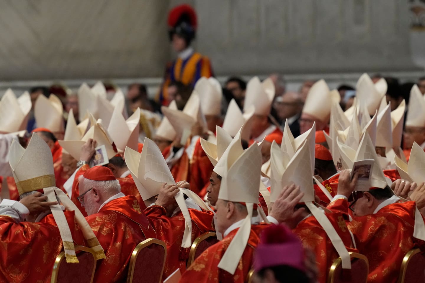 Cardinals adjust their mitre hats during a final Mass celebrated by cardinals inside St. Peter's Basilica before the conclave to elect a new pope, at the Vatican, Wednesday, May 7, 2025. (AP Photo/Gregorio Borgia)